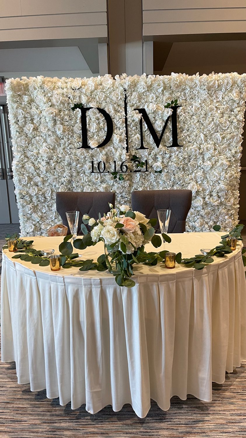 Sweetheart table with flower wall and monogram neon
